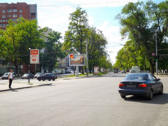 Фото рекламной плоскости по адресу пр-т. Пушкіна - вул. Андрія Фабра, бульвар Кучеревського, роллер 4х3/пр. Пушкина - ул. Серова, бульвар Кучеревского, роллер 4х3, светофор, большой транспортный поток, центр города