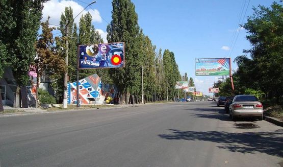 Фото рекламной плоскости по адресу Космонавтов, 98 - рынок Строй- материалов Г-образный щит над дорогой., стБ